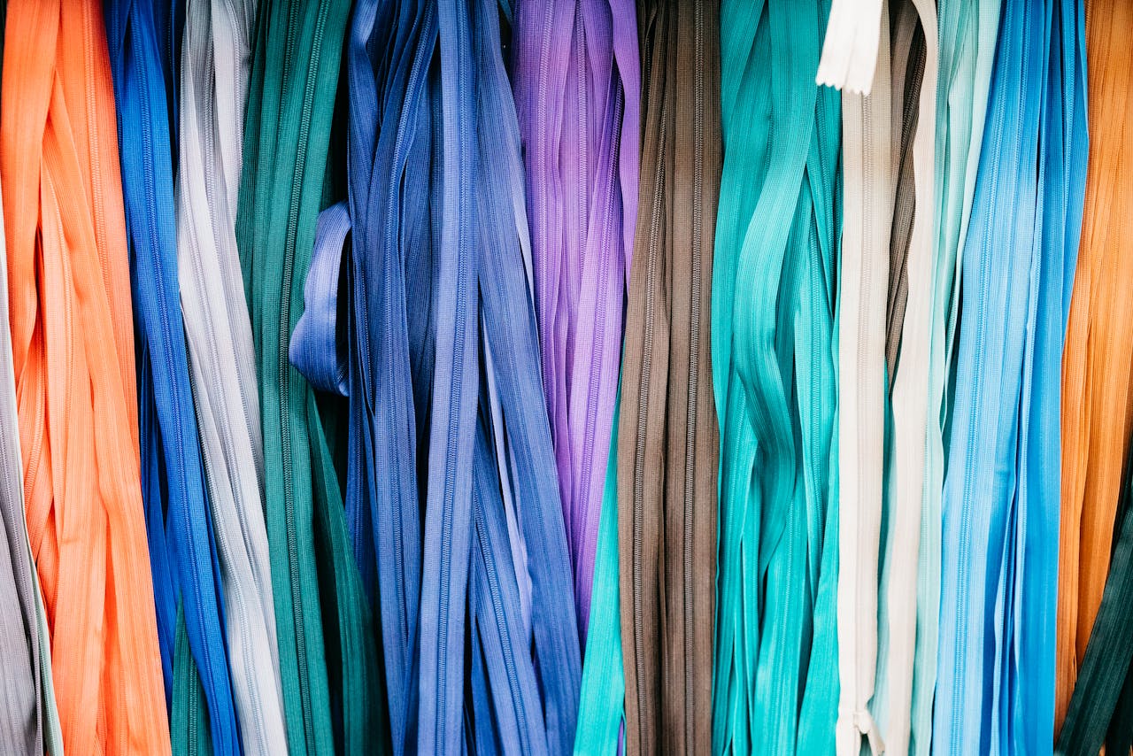 Vibrant assortment of hanging fabrics displaying various textures in a Bangkok market.