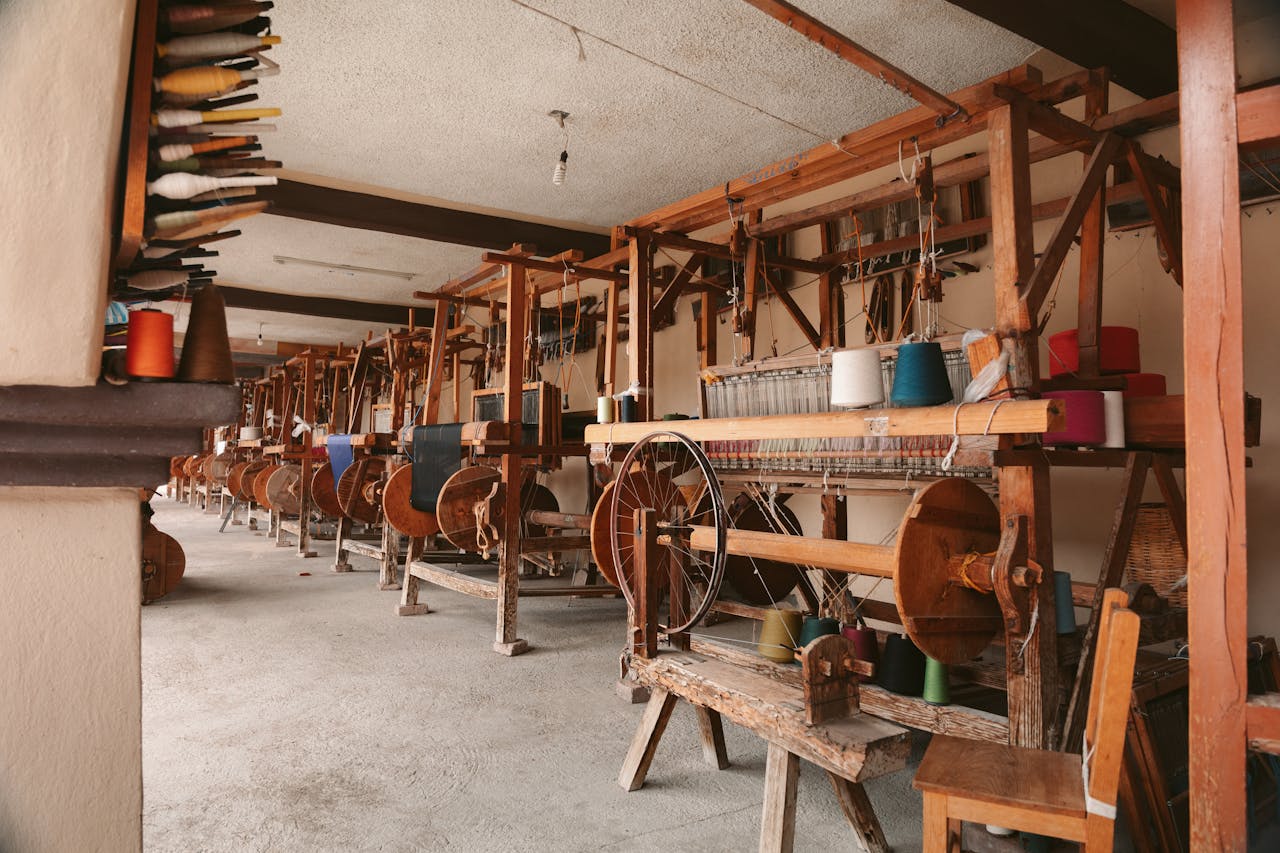 Explore a traditional weaving workshop in Oaxaca, showcasing handlooms and colorful yarn spools.